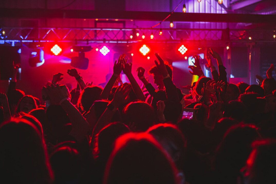 Crowd of people dancing at a colorful night party
