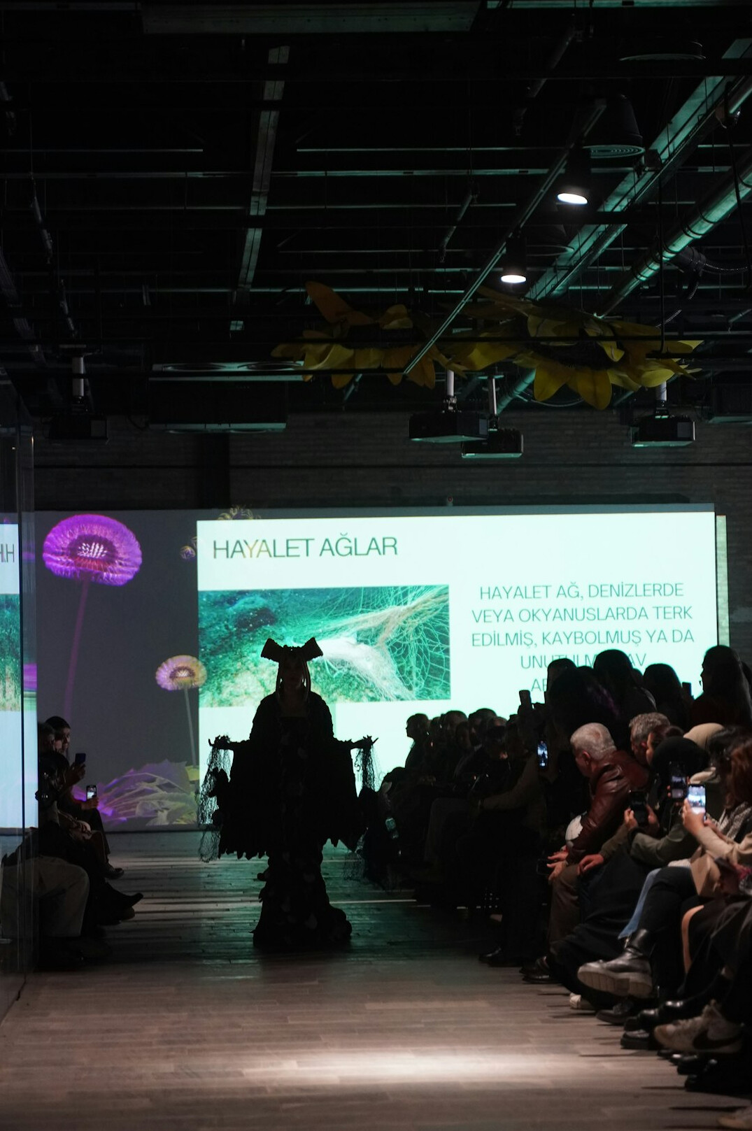 Wide view of a fashion show runway with audience